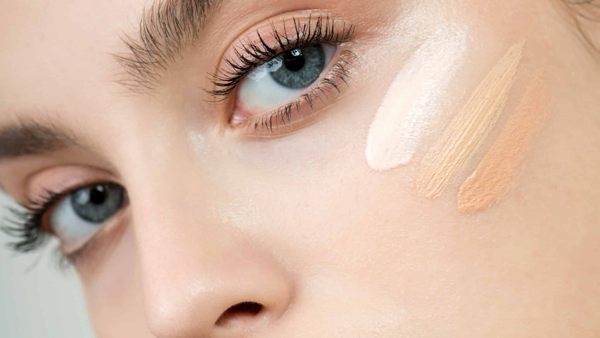 Hoe vind je de perfecte foundation? Zo breng je jouw foundation juist aan. Vrouw met foundation van drie verschillende kleuren op haar wang