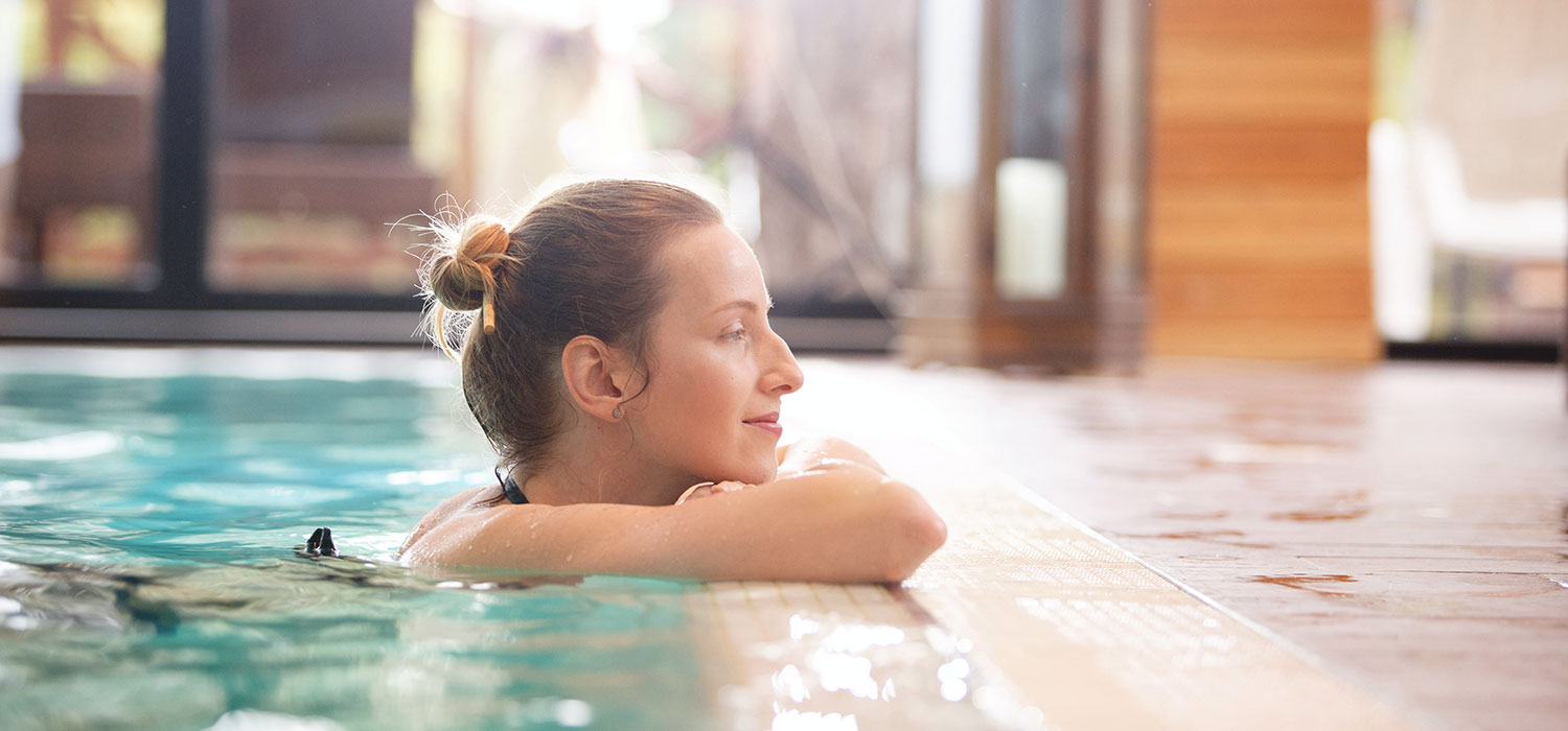 De verschillende spa types en hun specifieke weldaden Een vrouw ontspant in een spabad
