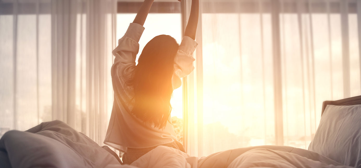 Het belang van een uitstekende slaap voor uw gezondheid Vrouw die wakker wordt