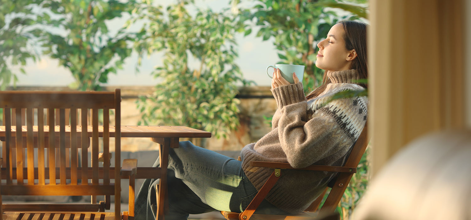 Welzijn en ontspanning tijdens de herfst met parafarmacieproducten Vrouw drinkt koffie op het terras in de herfst