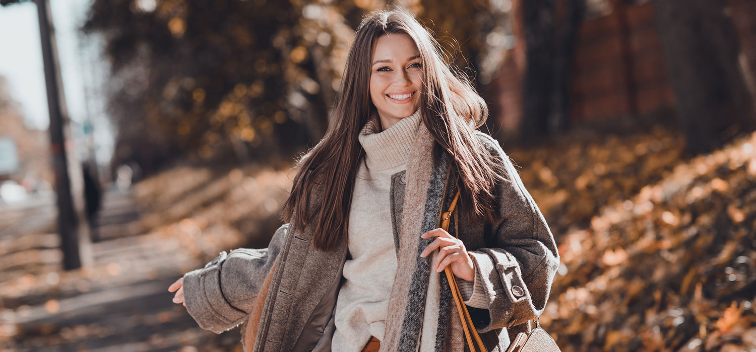 De kunst van het dragen van laagjes in de mode: voorbij de trend, een slimme keuze om de kou het hoofd te bieden Vrouw met jas in het bos in de herfst