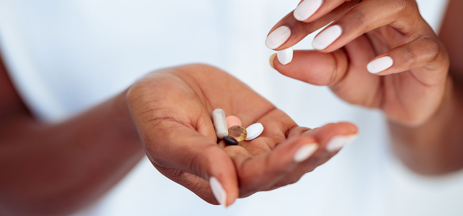 Natuurlijke remedies voor een jeugdige uitstraling Vrouw met pillen in haar hand