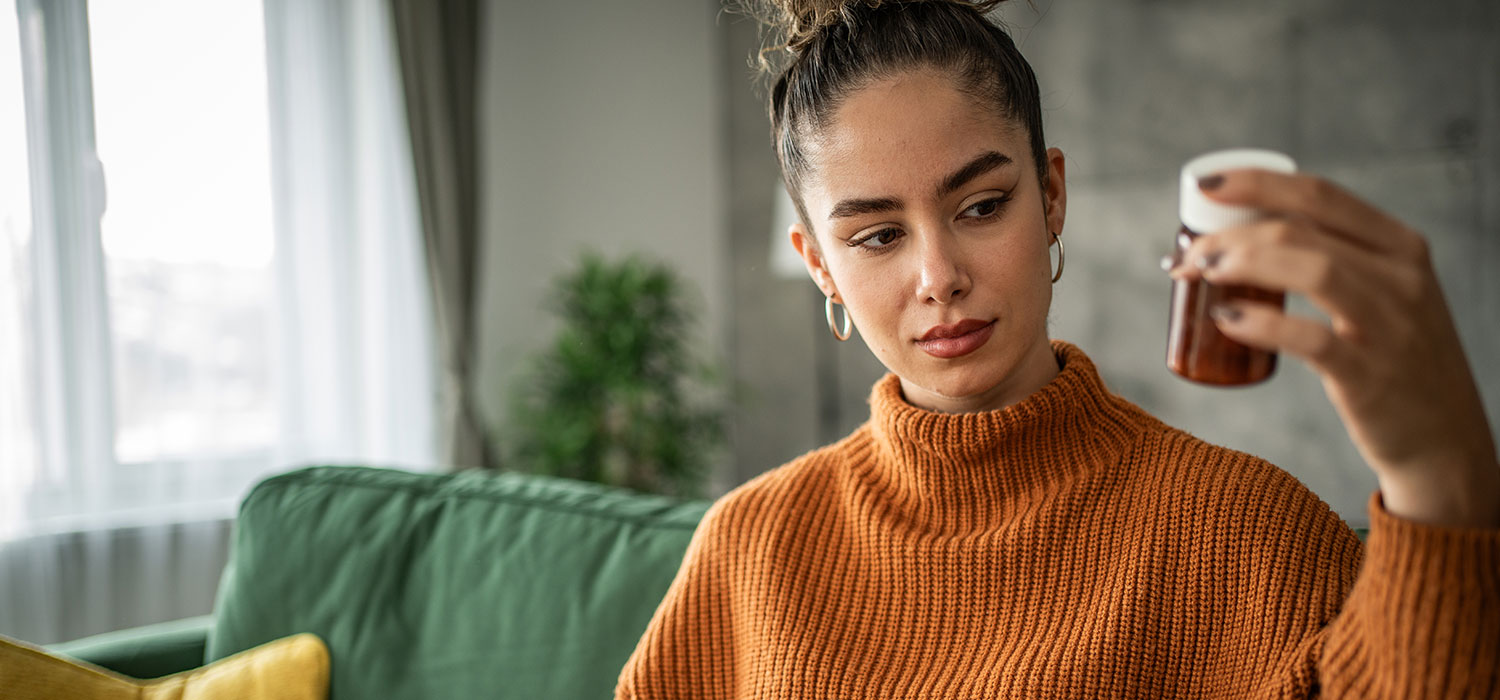 Voedingsmiddelen en medicijnen: welke mogelijke interacties? Vrouw leest de samenstelling van een medicijn