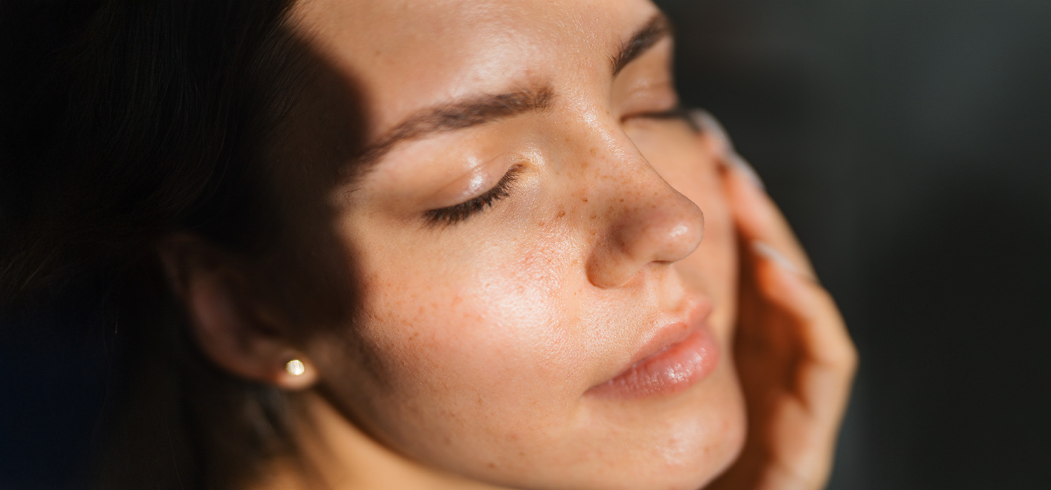 Happy Skin: de holistische aanpak voor een stralende huid Vrouw met haar gezicht in de zon