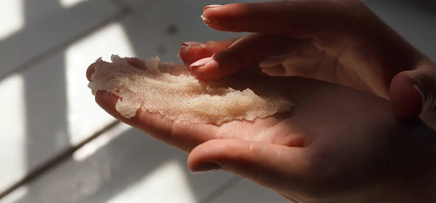 Ontdek de nieuwste style up beauty trends Vrouwenhanden houden scrub vast