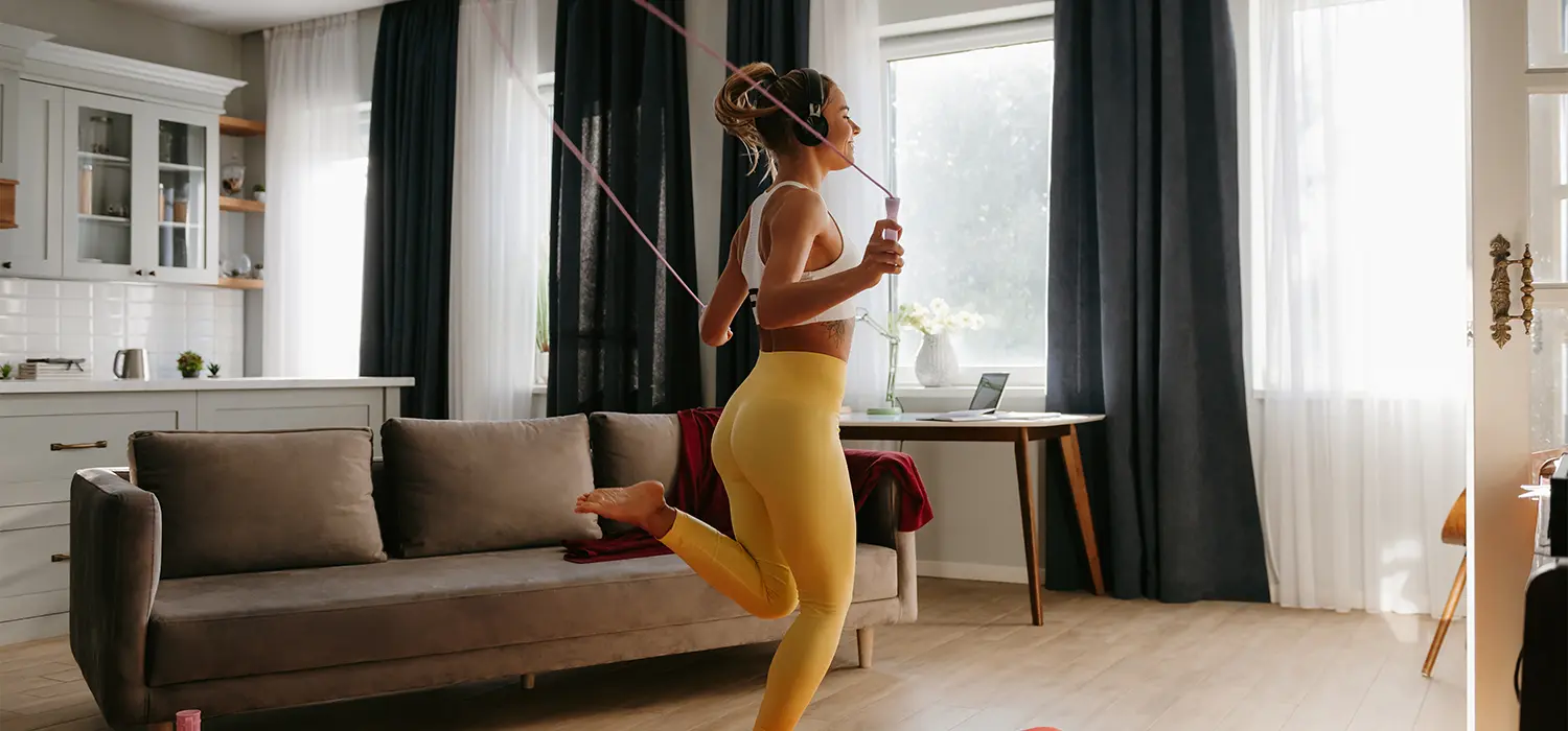 Essentiële fitness apparatuur voor beginners touwtje springende vrouw in haar woonkamer