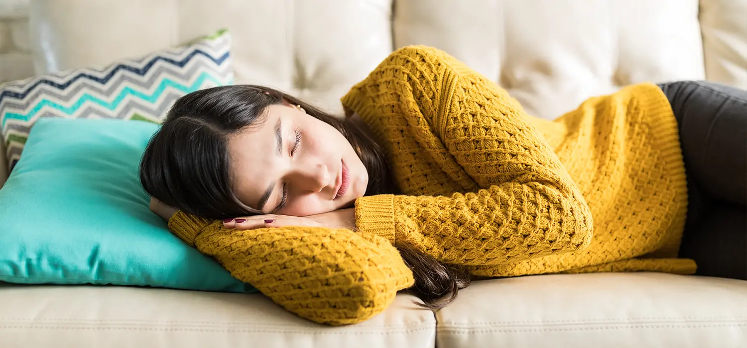 Stress & vermoeidheid: de onzichtbare vijanden die de huid in de winter beschadigen Vrouw die op de bank slaapt